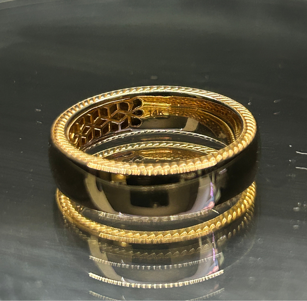 Yellow gold men's braided ring with raised rope edge and geometric inner detail on a reflective dark surface
